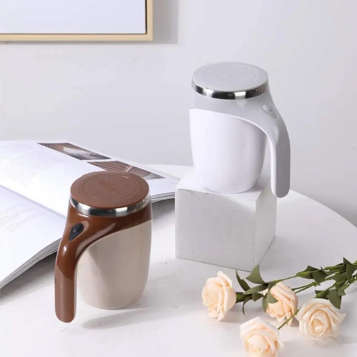 Two ceramic tea pots on a white surface with flowers and a magazine.